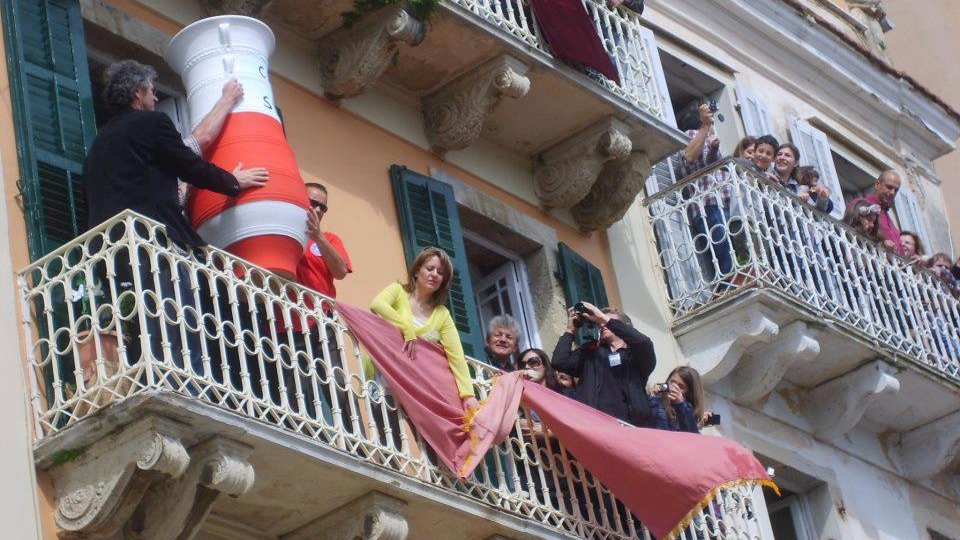 άνθρωποι ετοιμάζονται να ρίξουν πήλινο μπότη από μπαλκόνι κέρκυρα πάσχα 