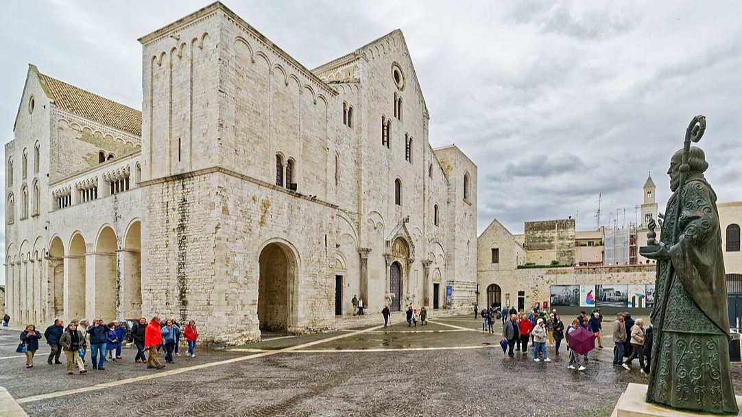 Κόσμος στο προαύλιο της εκκλησίας του Αγίου Νικολάου στο Μπάρι και το άγαλμα του Αγίου