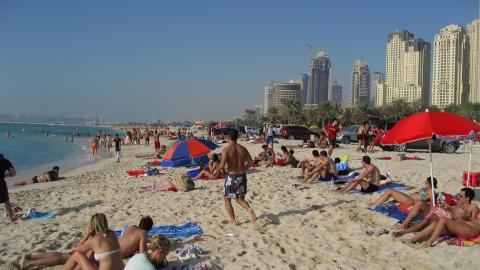 Dubai beach άνθρωποι στην παραλία διπλα από ουρανοξυστες