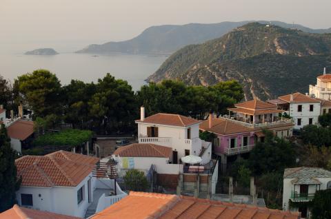 Η Αλόννησος (Χώρα) σε μια πανοραμική φωτογραφία με σκεπές σπιτιών και με φοντο τις ακτές του νησιού