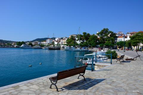 Παγκάκι στην παραλία της πόλης της Σκοπέλου και αγκυροβολημένες βάρκες