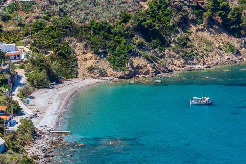 Η Παραλία Γλυφονέρι στη Σκόπελο μια βαρκούλα στα ανοιχτά και ο δρόμος που οδηγεί στην ακρογιαλιά