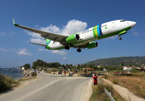 αεροπορικα για σκιαθο ένα αεροπλάνο κατα την προσγειωσή του στο αεροδρόμιο της Σκιάθο και ανθρωποι παρακολουθούν μια ανάσα έξω από τον διάδρομο προσγειωσης.υ