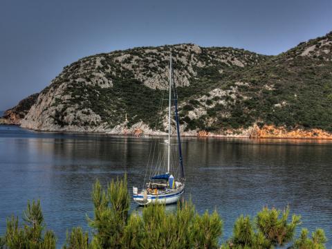 Ένα ιστιοφόρο στα ήρεμα νερά ενός κόλπου χαλκιδικη παραλιεσ