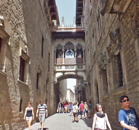 Στενό σοκάκι στη Γοτθική Συνοικία που ξεχωρίζει η γέφυρα μπαλκόνι σχεδιασμένη από τον Γκαουντί. Pont del Bisbe