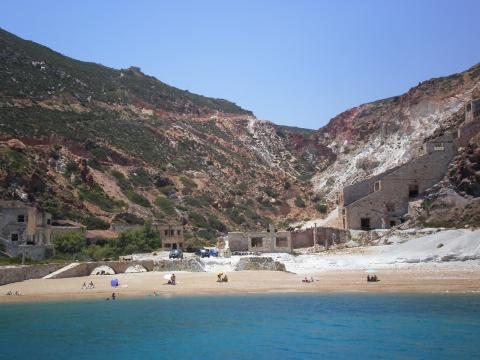 Παραλία στη Μήλο και στο φόντο τα εγκαταλελειμμένα ορυχεία θείου